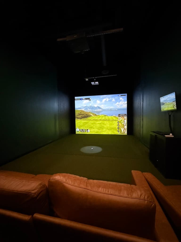 Lounge seating inside a Chip Shots simulator bay